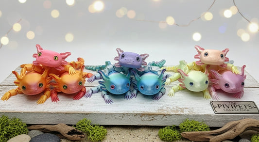 Colorful axolotl figurines on a wooden surface with a blurred light background